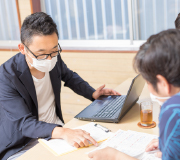 資料で説明している男性スタッフ